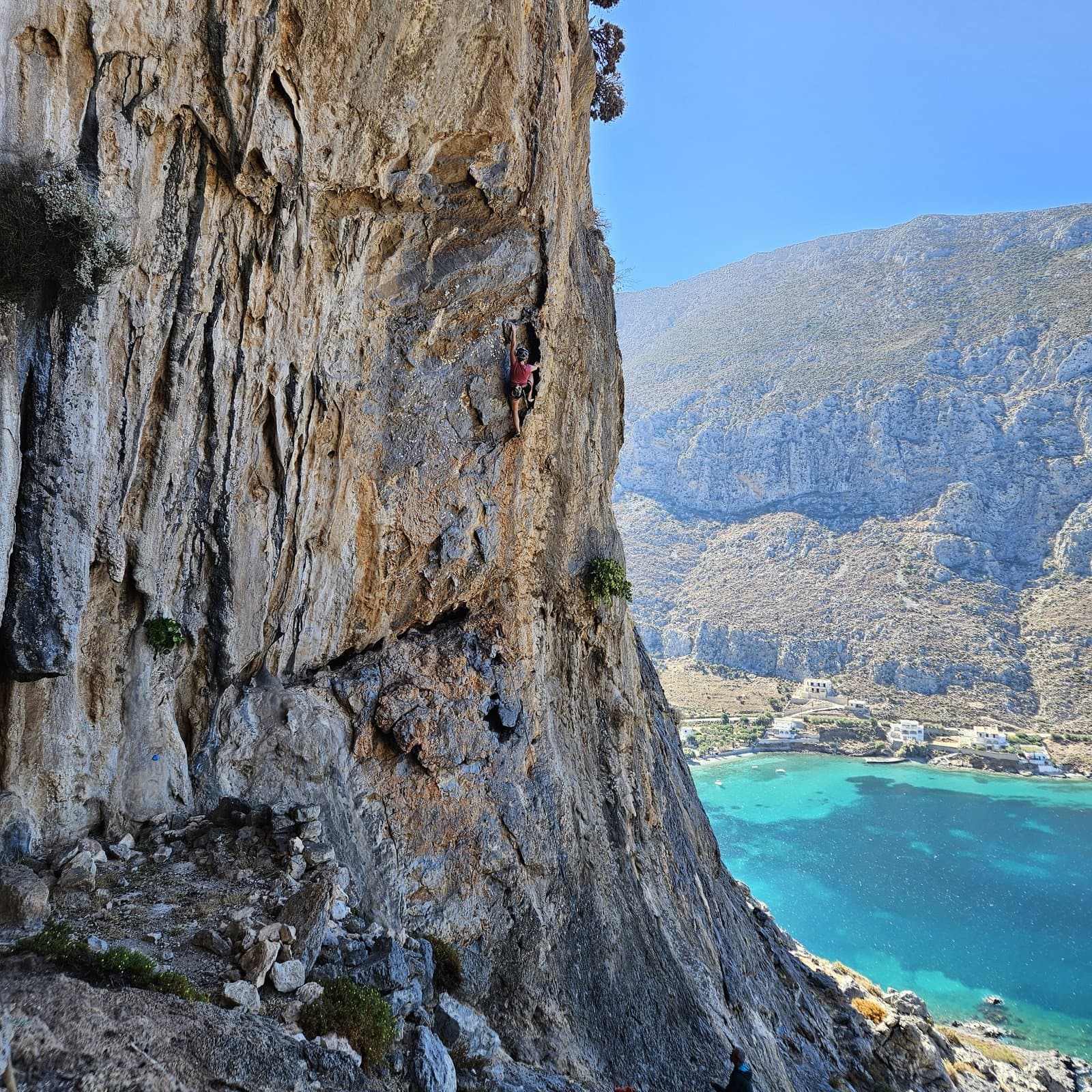 Climbing at Arhi Balcony, high above a turquoise bay