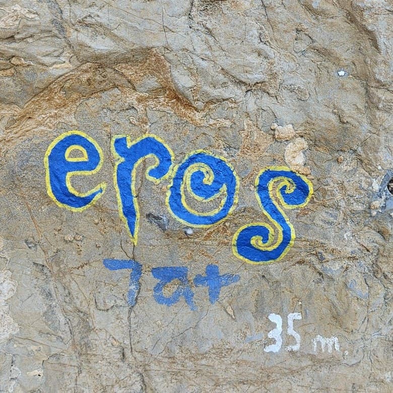 Route name Eros, 7a+, painted on the rock