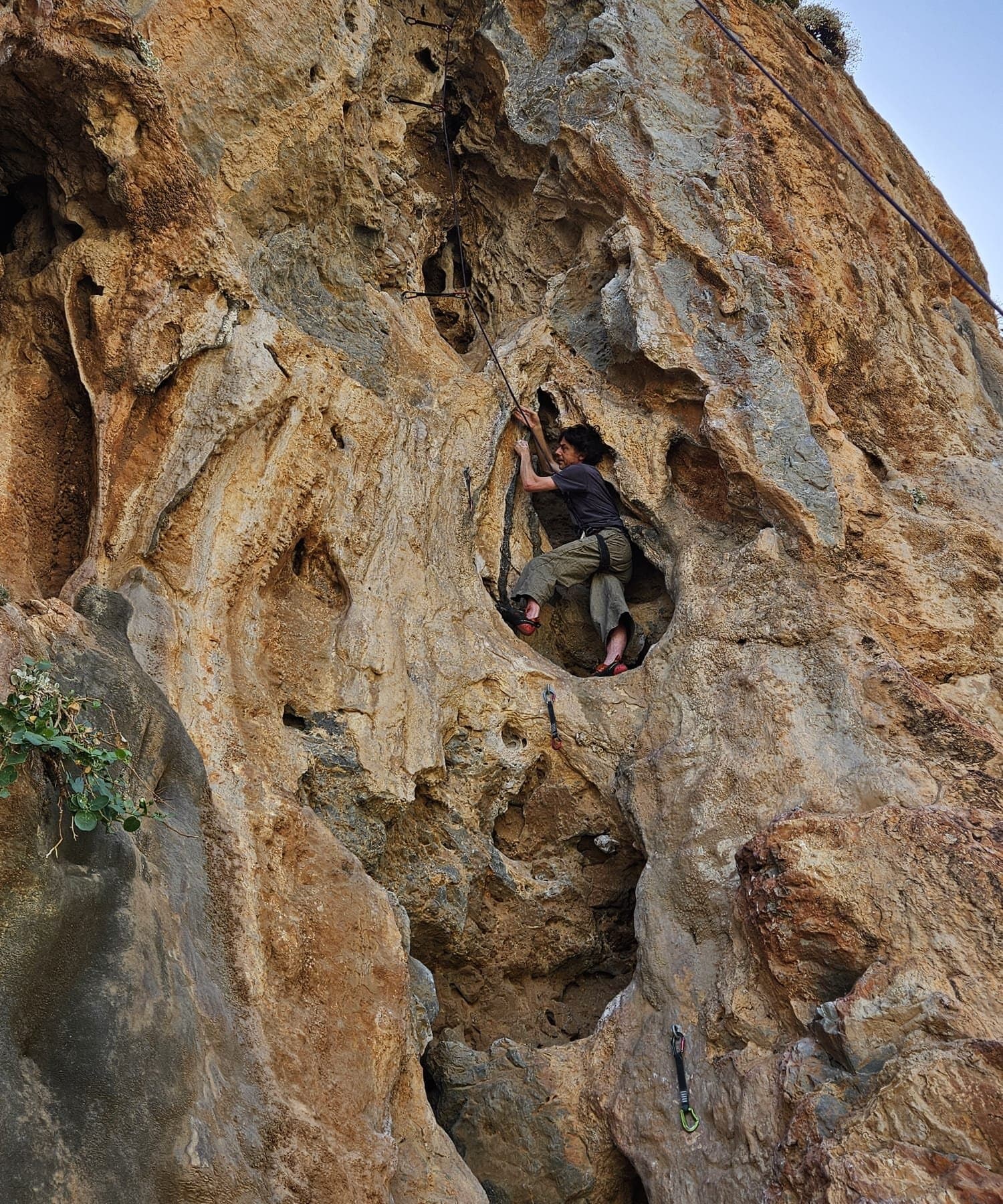 Climber in a large limestone pocket on Something Completely Different