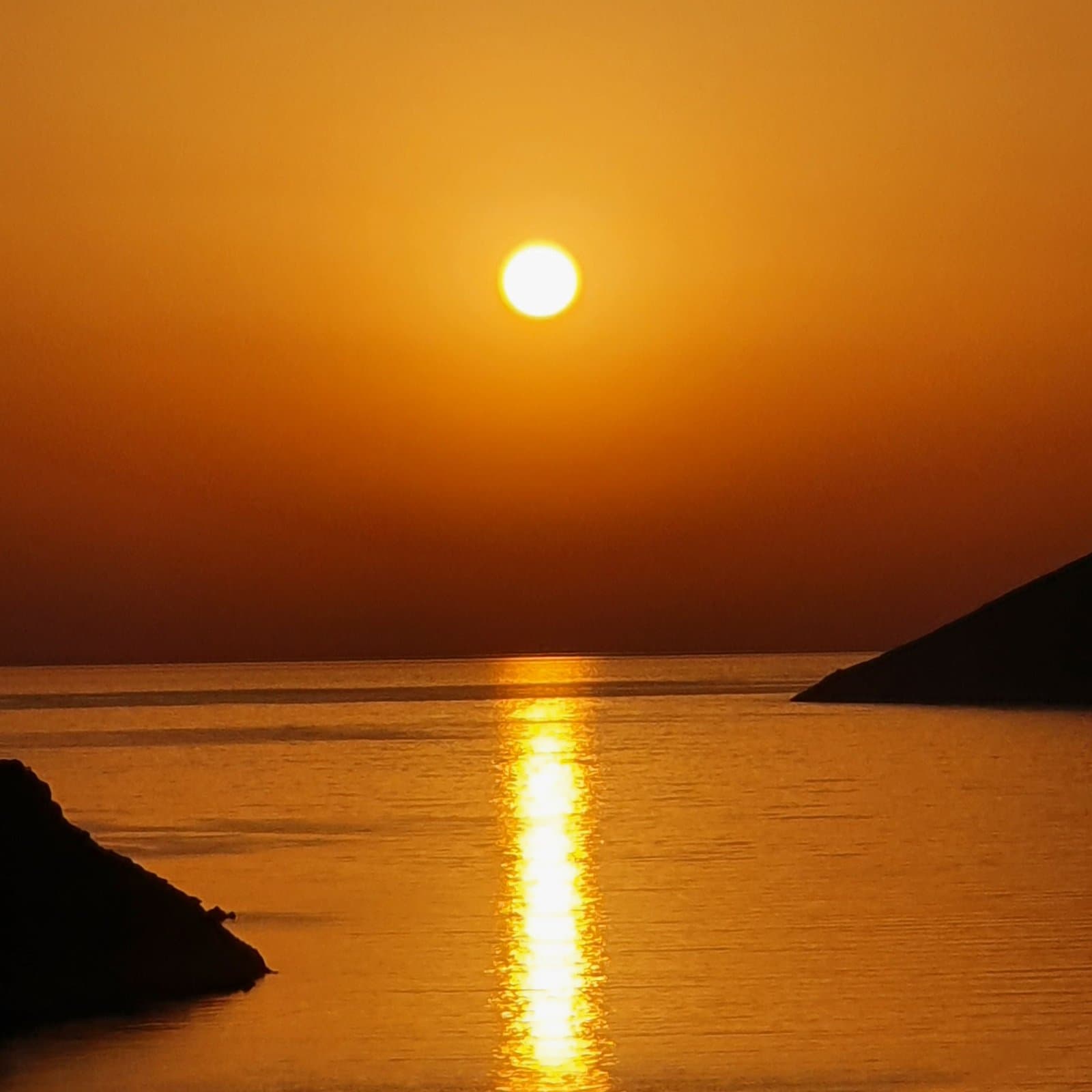 Sunset over the sea between two headlands